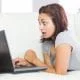 Mulher assustada olhando para o notebook