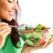 Mulher segurando um bowl de saladas