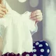 Uma mulher escolhendo roupas para seu bebê