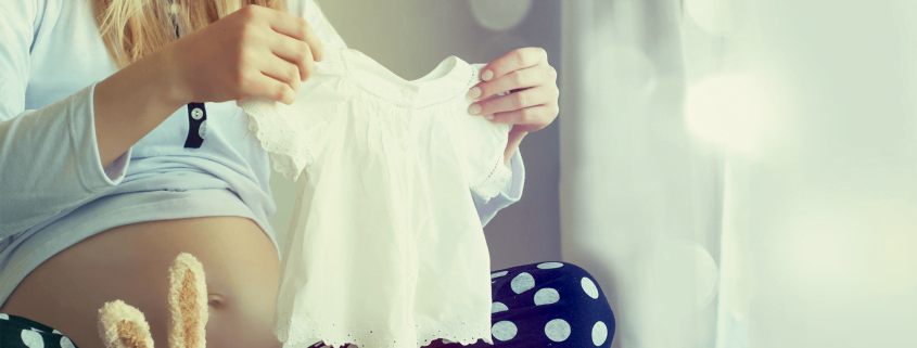 Uma mulher escolhendo roupas para seu bebê